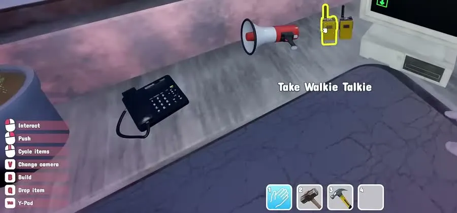 A walkie-talkie highlighted with the prompt Take Walkie Talkie on the ticket booth desk, next to a megaphone and a desk phone